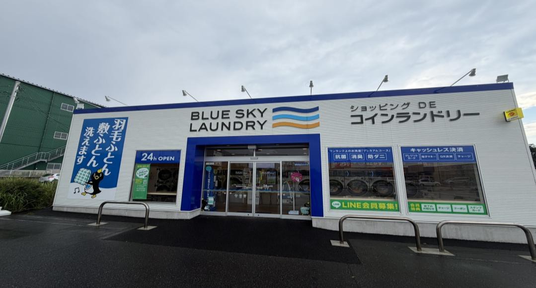 コインランドリー店内の大型サイネージと、利用中のお客さま